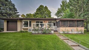 A two-story house with a covered front porch, a garage, and a well-maintained lawn. - Hugo Home, Direct Lake Access & Private Dock! (Hugo)