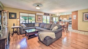 A spacious living room with a sectional sofa, a coffee table, and a dining area with a table and chairs. - Hugo Home, Direct Lake Access & Private Dock! (Hugo)