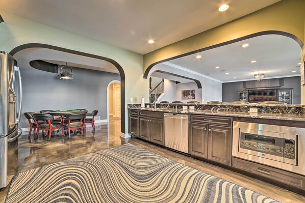 A modern kitchen with a central island, stainless steel appliances, and a dining area with a pool table. - Luxe Waterfront Home w/ Private Lake Access! (West Branch)