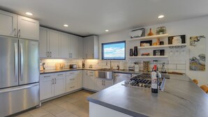 A modern kitchen with white cabinets, stainless steel appliances, and a large window providing natural light. - Mt Hood Views: Modern Underwood Home w/ Deck! (Underwood)