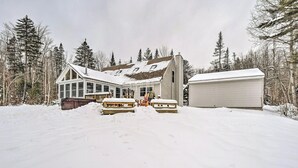 A snow-covered house with a large deck and a garage. - Mount Holly Vacation Rental w/ Hot Tub! (Mount Holly)