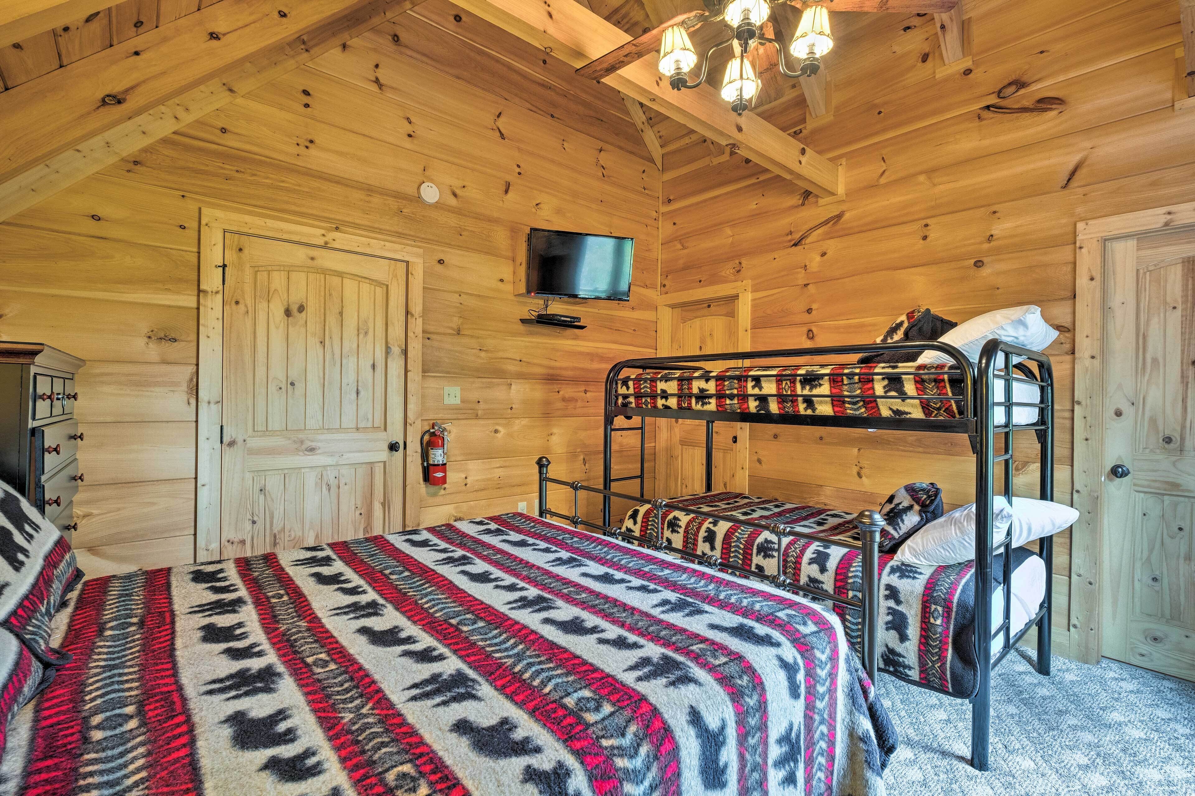 A wooden cabin room with a bunk bed, a television, and a fire extinguisher.