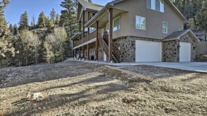 A two-story house with a stone foundation, a covered porch, and a staircase leading to the upper level. - Mammoth Creek Apt. Between Bryce Canyon & Zion! (Hatch)