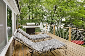 A deck with two lounge chairs, a grill, and a dining table. - Peaceful Fisherman's Paradise w/ Deck + Fire Pit! (Winthrop)