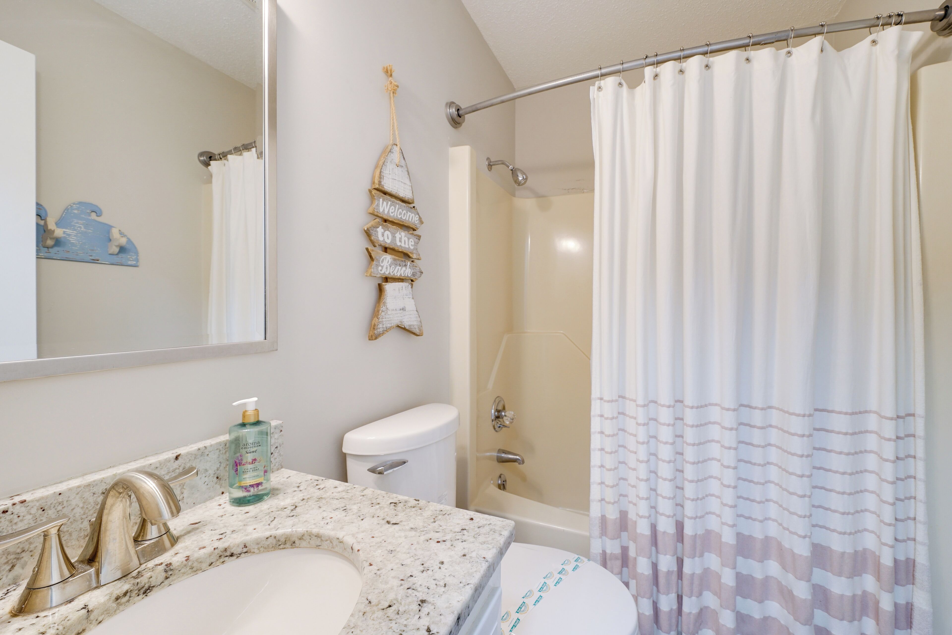 A bathroom with a sink, toilet, and shower.