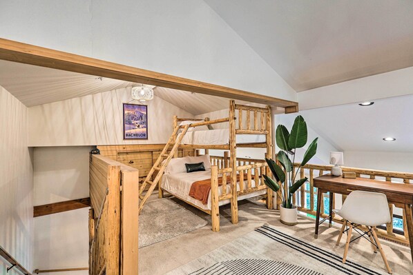 A bunk bed with a desk and chair, a potted plant, and a poster on the wall. - Mountain-modern Unit: Golf, Hike, Ski & More! (Bend)