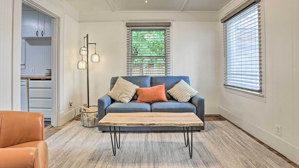 A living room with a blue sofa, a wooden coffee table, a floor lamp, and a ceiling fan.
