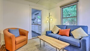A living room with a blue sofa, an orange armchair, and a wooden coffee table.