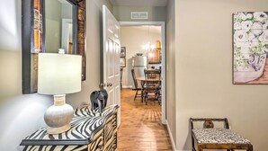 A hallway with a zebra-patterned console table, a lamp, a bench, and a painting on the wall. - Pet-friendly Brownsville Retreat w/ Porch! (Brownsville)