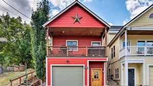 A two-story house with a red exterior, a balcony, and a garage. - Quiet Park City Home w/ Hot Tub - Walk to Main St! (Park City)