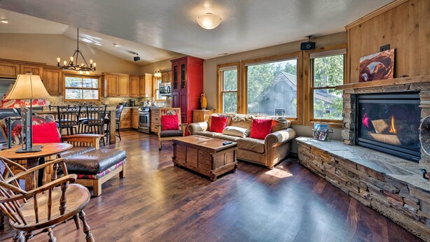 A spacious living room with a fireplace, wooden furniture, and large windows. - Quiet Park City Home w/ Hot Tub - Walk to Main St! (Park City)