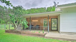 Une terrasse couverte avec une pancarte « BIENVENUE », une clôture en bois et une antenne parabolique.