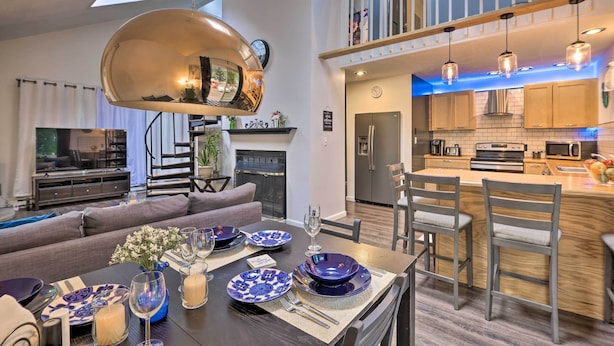 A modern kitchen with a central island, built-in appliances, and pendant lighting.