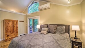 A bedroom with a large bed, a wooden wardrobe, an air conditioning unit, and a window. - Quiet Studio Escape ~ 2 Mi to Blue Ridge Parkway! (West Jefferson)