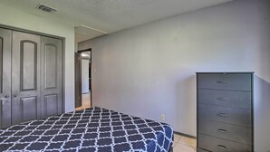 A bedroom with a bed, a dresser, and a door. - San Antonio Abode w/ Yard: 17 Mi to Downtown! (San Antonio)