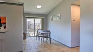 A kitchen with a window, a dining table with chairs, and a sliding glass door leading to a patio. - San Antonio Abode w/ Yard: 17 Mi to Downtown! (San Antonio)