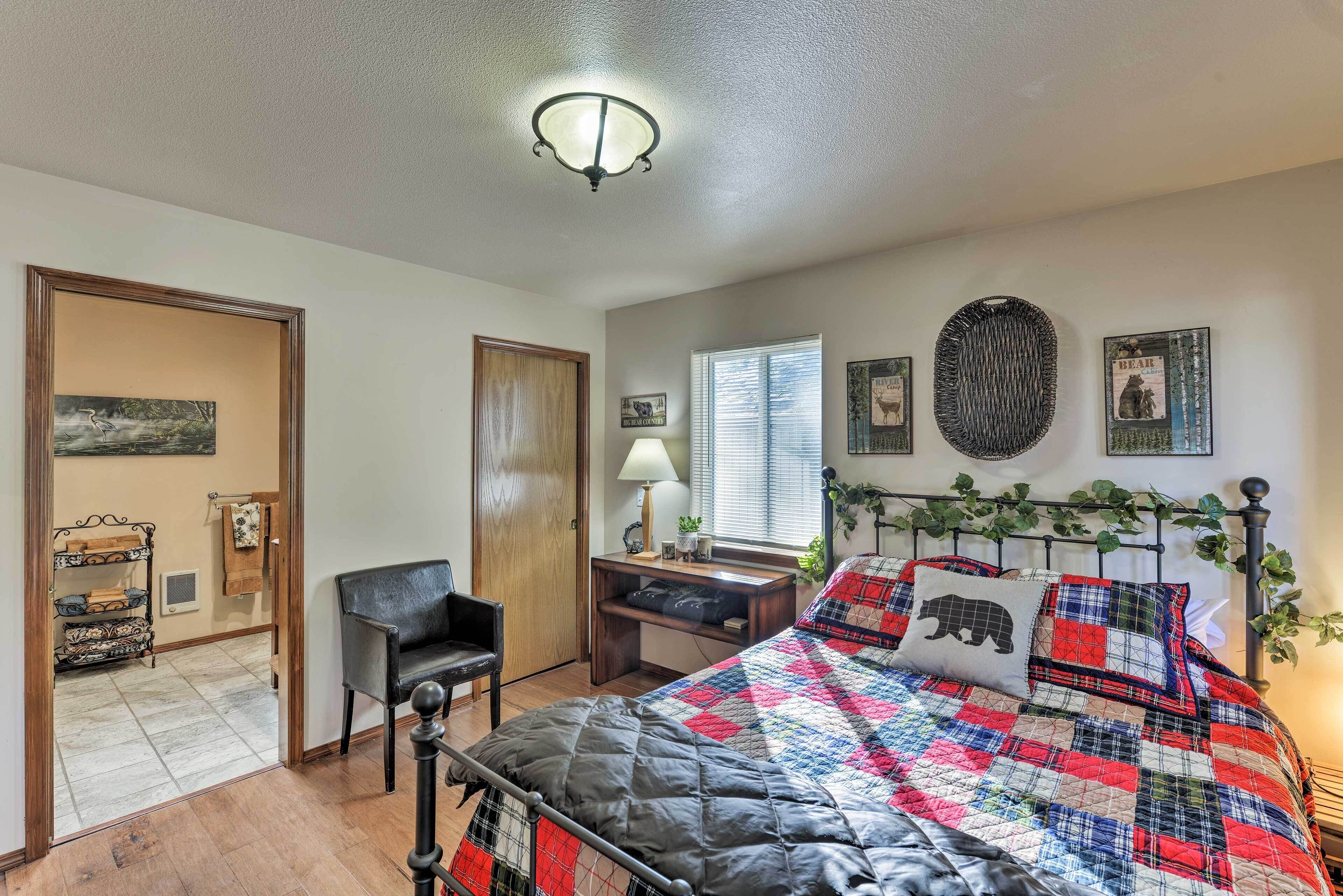 A bedroom with a bed, a desk, a chair, and a window.