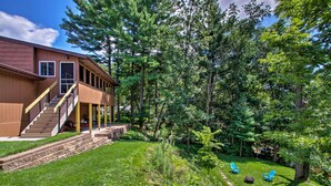 A modern house with a covered porch, a staircase, and a well-maintained lawn with outdoor seating. - 'riversong' Waterfront La Crosse Home w/ Dock (La Crosse)