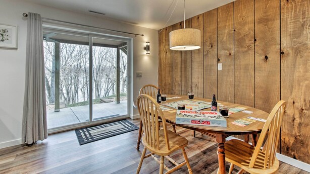 A dining area with a wooden table, chairs, and a board game. - 'riversong' Waterfront La Crosse Home w/ Dock (La Crosse)