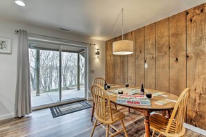 A dining area with a wooden table, chairs, and a board game. - 'riversong' Waterfront La Crosse Home w/ Dock (La Crosse)