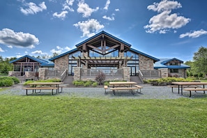 A building with a prominent entrance, outdoor seating area, and a clear sky.