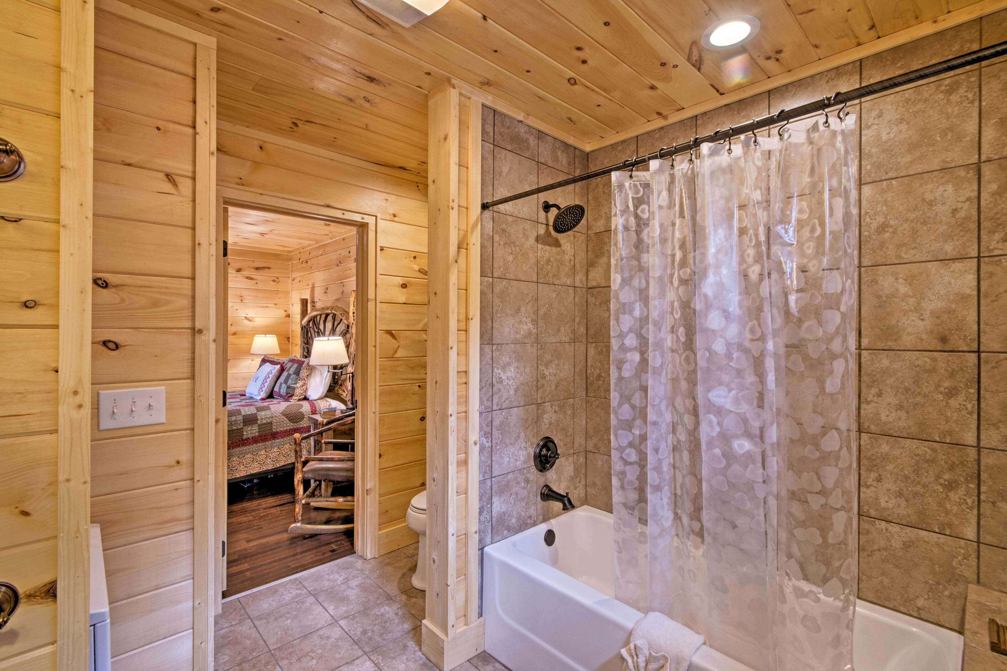 A wooden interior with a bathroom featuring a bathtub, shower curtain, and tiled walls.