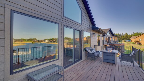 A modern deck with large windows overlooking a swimming pool, outdoor furniture, and a clear view of the surrounding landscape. - Lakefront Luxury - 1 MI to Buckhorn Boat Landing (New Lisbon)