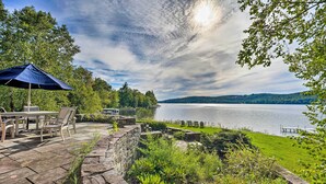A patio with stone flooring, outdoor furniture, and a view of a lake.