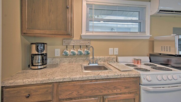 A kitchen with a built-in stove, a coffee maker, and a window with blinds. - Studio 1 Mi to Dtwn Hot Springs & Nat'l Park! (Hot Springs)
