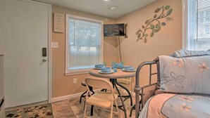 A compact room with a bed, a dining table with chairs, a TV mounted on the wall, and a door with a sign. - Studio 1 Mi to Dtwn Hot Springs & Nat'l Park! (Hot Springs)