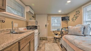 A compact bedroom with a bed, bedside table, and a chair. A kitchen area with a stove, sink, and microwave is visible. - Studio 1 Mi to Dtwn Hot Springs & Nat'l Park! (Hot Springs)
