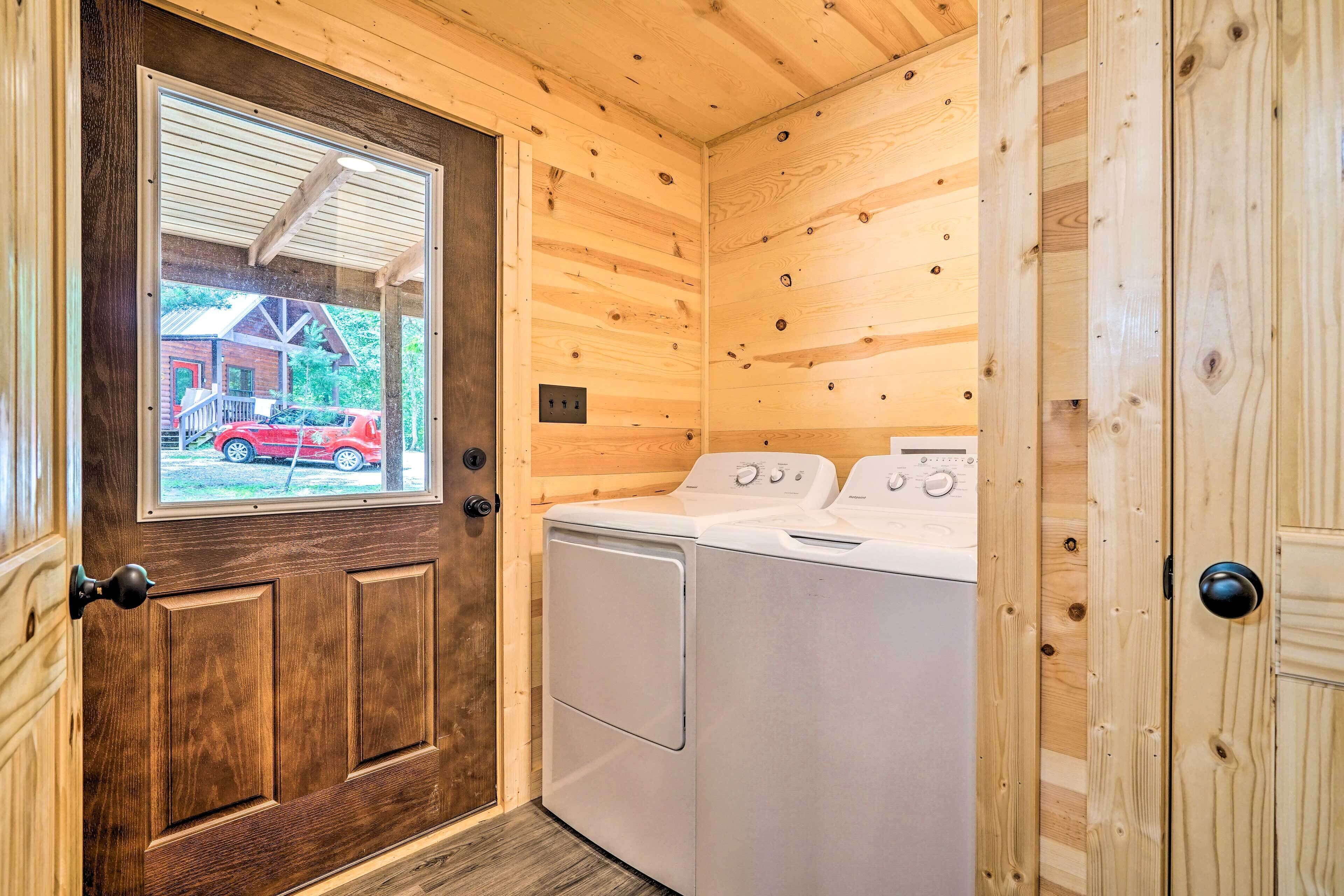 A laundry room with wooden walls and a door with a window.