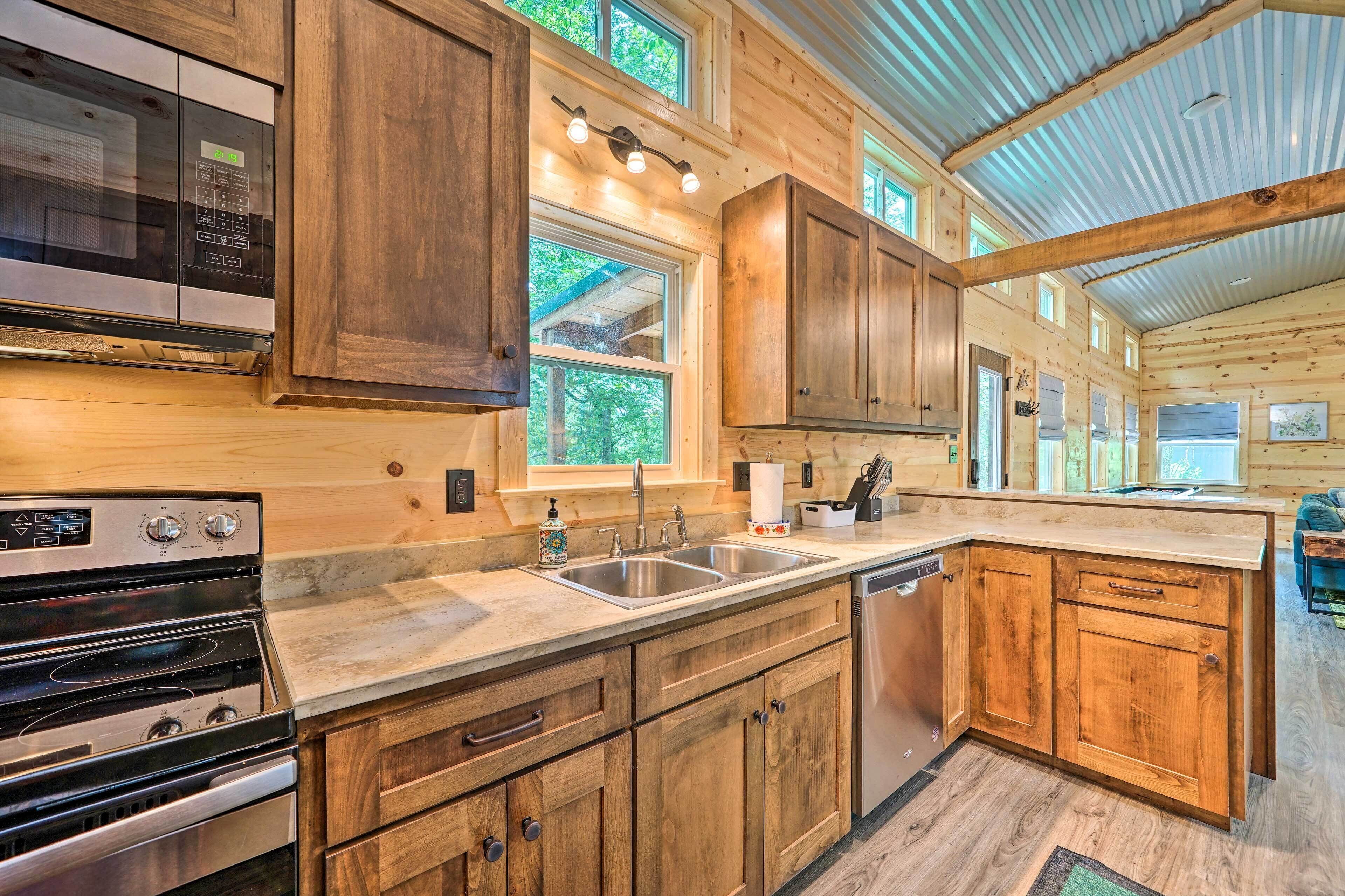 A kitchen with wooden cabinets, stainless steel appliances, and a large window.