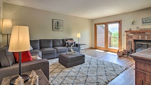 A living room with a grey sofa, a coffee table, and a fireplace. - Timber Creek Townhome w/ 2 Decks & Mtn Views! (West Dover)