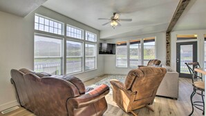 A spacious living room with large windows, a ceiling fan, and a view of the outdoors. - Tranquil Indigo Getaway < 3 Mi to Hot Pools! (Lava Hot Springs)