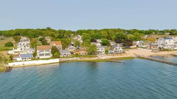 Houses line the shoreline, offering stunning views of the calm sea and lush surroundings.