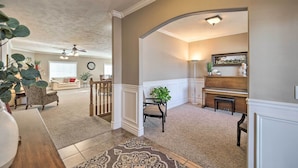 A spacious living room with a piano, a dining area, and a staircase leading to another level. - Spacious Idaho Home: Ski, Hike, & Fish! (Rexburg)