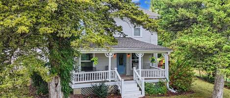 A two-story house with a front porch, a covered entryway, and a small front yard.