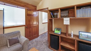 A room with a wooden bookshelf, a couch, and a door. - Warm Mccall Condo: Half-mile to Payette Lake! (McCall)