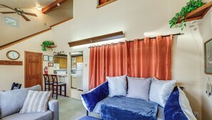 A bedroom with a bed, a sofa, and a dining area in the background. - Warm Mccall Condo: Half-mile to Payette Lake! (McCall)