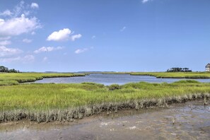 A coastal landscape with a clear sky, a body of water, and grassy areas. - Resort Amenities & Screened Porch: Ocean View Home (Ocean View)