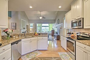 A spacious kitchen with white cabinetry, granite countertops, and a central island. - Resort Amenities & Screened Porch: Ocean View Home (Ocean View)
