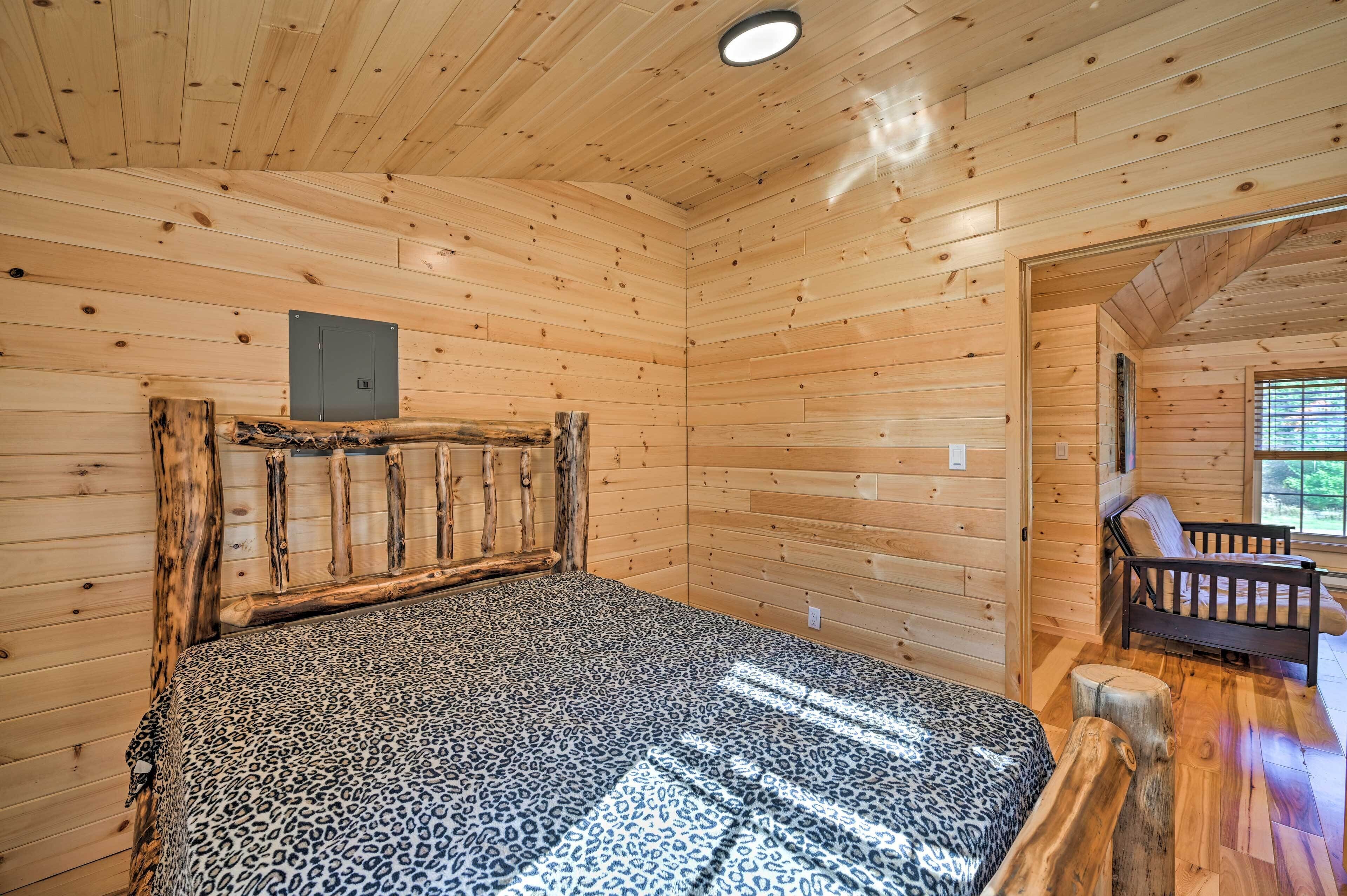A wooden cabin room with a bed, a bench, and a small table.