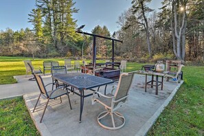 Une terrasse extérieure avec une table et des chaises, un barbecue et un luminaire alimenté par énergie solaire.