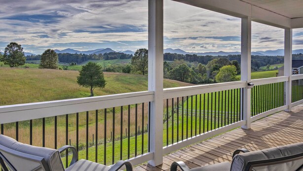 A covered porch with wooden flooring, white railings, and two cushioned chairs. - Unique Blue Ridge Haven, 12 Mi to Asheville! (Leicester)