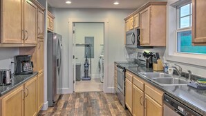 A modern kitchen with wooden cabinets, stainless steel appliances, and a granite countertop. - Unique Blue Ridge Haven, 12 Mi to Asheville! (Leicester)