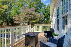 A deck with a fire pit, outdoor seating, and a view of a tree and house. - 'the Blackberry Place' in Charlotte: Fire Pit (Charlotte)