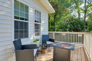 Una terraza con mobiliario exterior, una parrilla y una planta en maceta.