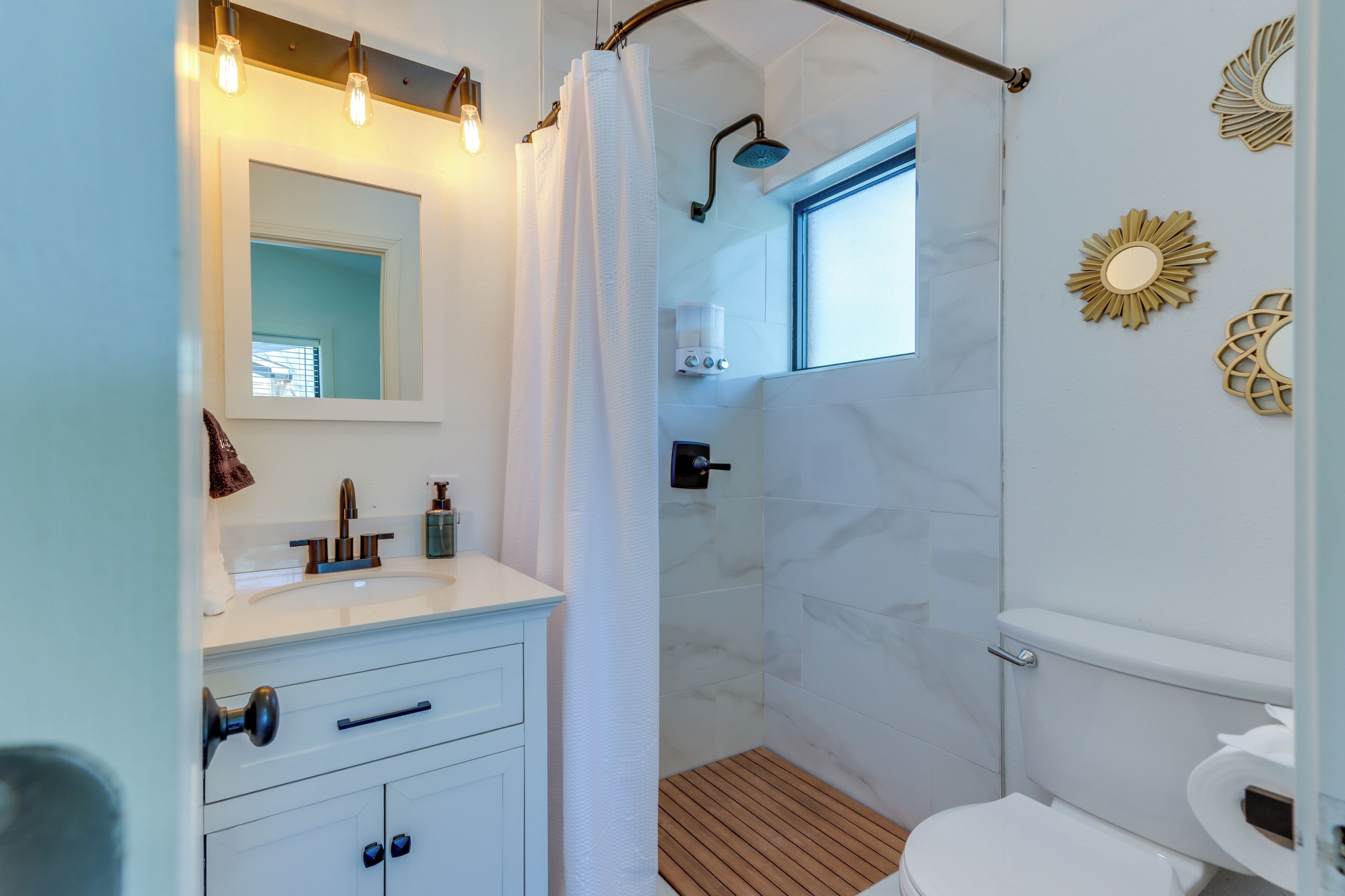 A modern bathroom with a shower, toilet, and vanity.