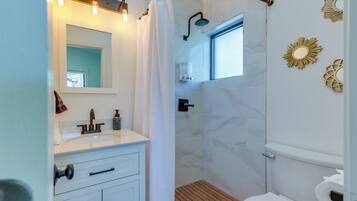 A modern bathroom with a shower, toilet, and vanity.